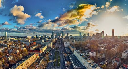 Beautiful panoramic aerial drone view to the ?enter of modern Warsaw city with silhouettes of skyscrapers in in the rays of the setting winter January sun - amazing sunset, Polandの写真素材