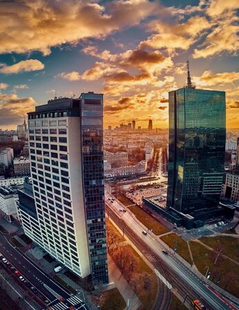 Beautiful panoramic aerial drone view to the ?enter of modern Warsaw city with silhouettes of skyscrapers in in the rays of the setting winter January sun - amazing sunset, Polandの写真素材