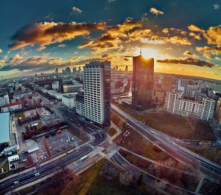 Beautiful panoramic aerial drone view to the ?enter of modern Warsaw city with silhouettes of skyscrapers in in the rays of the setting winter January sun - amazing sunset, Polandの写真素材