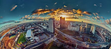Beautiful panoramic aerial drone view to the ?enter of modern Warsaw city with silhouettes of skyscrapers in in the rays of the setting winter January sun - amazing sunset, Polandの写真素材