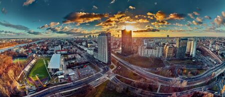 Beautiful panoramic aerial drone view to the ?enter of modern Warsaw city with silhouettes of skyscrapers in in the rays of the setting winter January sun - amazing sunset, Polandの写真素材