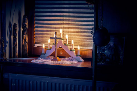 Symbols of the Nativity of Christ in a residential interior: candles, cross with a crucifix, Menorah...