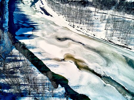 Panoramic aerial view: beautiful spring landscape: the Ulba river in Kazakhstan wakes up from winter sleep - ice drift - snow and ice are melting in the mountains, the bright sun is shining, Qazaqstanの写真素材