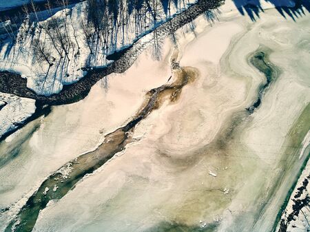 Panoramic aerial view: beautiful spring landscape: the Ulba river in Kazakhstan wakes up from winter sleep - ice drift - snow and ice are melting in the mountains, the bright sun is shining, Qazaqstanの写真素材