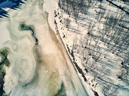 Panoramic aerial view: beautiful spring landscape: the Ulba river in Kazakhstan wakes up from winter sleep - ice drift - snow and ice are melting in the mountains, the bright sun is shining, Qazaqstanの写真素材