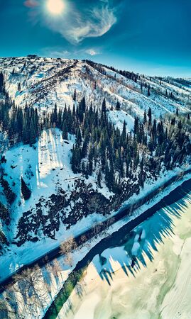 Panoramic aerial view: beautiful spring landscape: the Ulba river in Kazakhstan wakes up from winter sleep - ice drift - snow and ice are melting in the mountains, the bright sun is shining, Qazaqstanの写真素材
