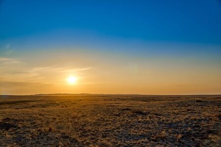 Panoramic view: beautiful spring landscape: spring huge great steppe wakes up from winter sleep - snow and ice just melted, sunset, Kazakhstan (Qazaqstan)の写真素材