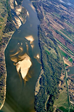 Beautiful panoramic aerial landscape - top view of the Vistula river and fields - view from the window of the plane landing at the Warsaw (Poland) at spring at sunsetの写真素材