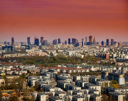 Beautiful panoramic aerial cityscape - view from the window of the plane landing at the center of Warsaw (Poland) with skyscrapers, with parks and residential areas, early spring at sunsetの写真素材