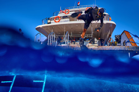 The beauty of the underwater world - diver jumping from boat into water - split photo - scuba diving in the Red Sea, Egypt.の写真素材