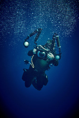 The beauty of the underwater world - underwater photographer with camera and underwater lamps -...
