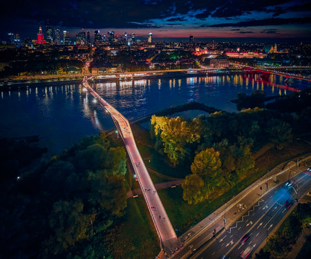 Beautiful panoramic aerial drone night sunset view to the new pedestrian and bicycle bridge connecting the banks of the Vistula, Warsaw, Poland, EU.の写真素材