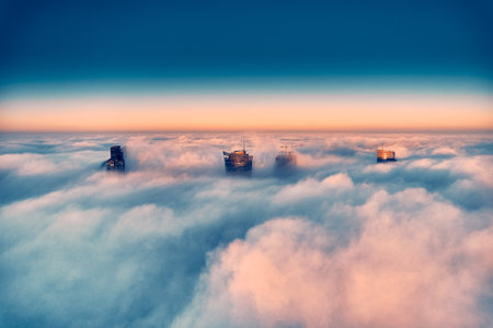 Panoramic aerial drone view of skyscrapers sticking out of low fog at sunrise, Warsaw, Poland, EU.の写真素材