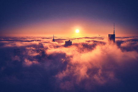 Beautiful panoramic aerial drone view of skyscrapers sticking out of low fog at sunrise, Warsaw, Poland, EU.の写真素材