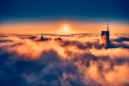 Beautiful panoramic aerial drone view of skyscrapers sticking out of low fog at sunrise, Warsaw, Poland.の写真素材