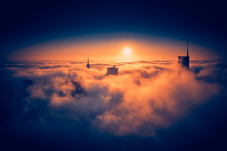 Panoramic aerial drone view of skyscrapers sticking out of low fog at sunrise, Warsaw, Poland, EU.の写真素材