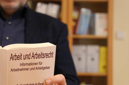 Lawyer for employment law holding a book in his handsの写真素材