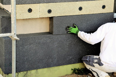 Construction workers yield house facade