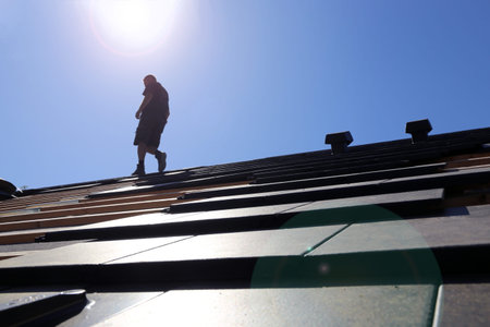 Silhouette of a roofer in the backlight