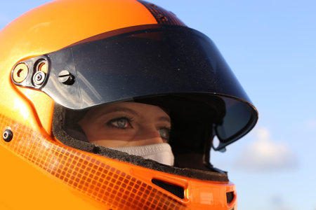 Female race car driver wears helmet and balaclava