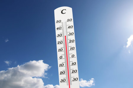 Symbol image: Thermometer in front of blue sky shows warm temperatures