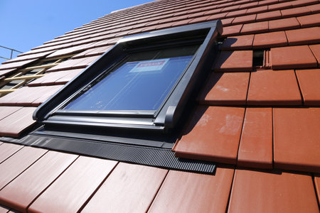 Neues Dachfenster des Herstellers âVeluxâ an einem neu eingeckten Ziegeldachのeditorial素材