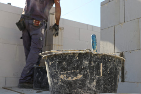 Construction worker (bricklayer) works on the construction site