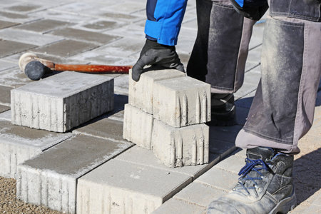 Construction worker lay paving stones