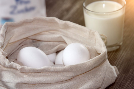 Symbolic image of baking ingredients: Eggs in a fabric bag