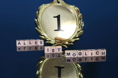 Symbol image: Close-up of a (gold) medal with german text ALLES IST MÃGLICH (All is possible)の写真素材
