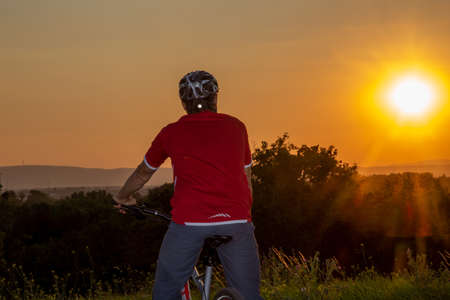 Symbolic image: Mountain biker enjoying the view at sunset (model released)の写真素材