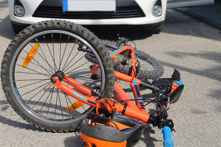 Symbolic image of a bicycle accident in road traffic: bicycle lying on the road in front of a carの写真素材
