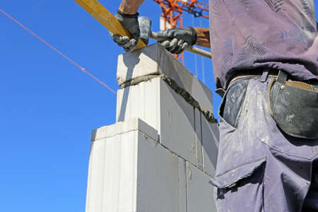 Construction worker (bricklayer) works on the construction siteの写真素材