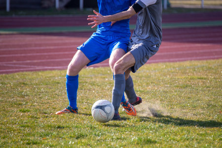 Symbolic image of amateur football: Football players in a duel for the ballの写真素材