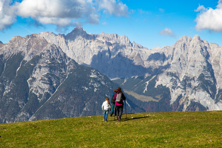 Hiking with children in Seefeld, Tyrol: Family hiking across an alpine meadow, the Wetterstein Mountains in the backgroundの写真素材
