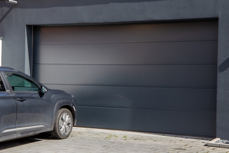 Modern garage door (sectional door) with car parked in frontの写真素材