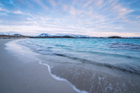Waves crashing on the beach in Sommaroy, Norwayの写真素材