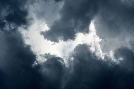 A close up photograph of dramatic, dark, stormy thunder clouds taken in the late afternoon in the Madikwe Game Reserve, South Africa.の写真素材