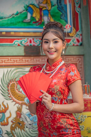 Asian girl in red dress standing in holy place on Chinese New Year.の写真素材