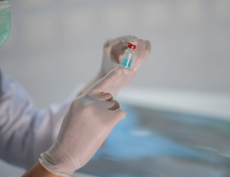 A doctor or scientist in a laboratory carrying a bottle containing a liquid vaccine for the...