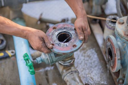 Pipe wrench used for well maintenance.Pipeline to the underground water pipe on a blurred background.の写真素材