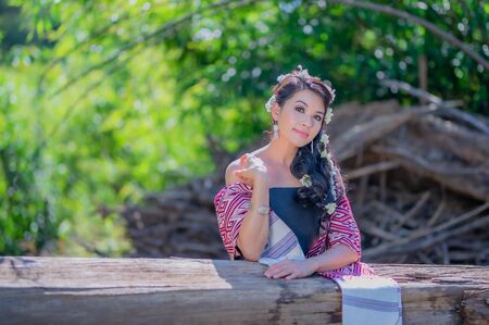 Beautiful Thai women wearing traditional Thai clothes sitting on a log in the river. Woman concept.の写真素材