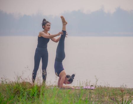 Portrait of beautiful young woman wearing black sportswear working out in lakeside garden.の写真素材