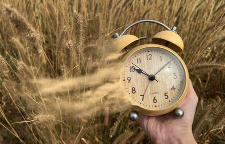 The concept of leaving time. Old hours, in hands. Old alarm clock. Vintage clock as time passing and pass away conceptの写真素材