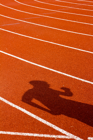 Shadow of man on red running track. Sport conceptの写真素材