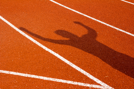 shadow of man on a stadium running path. Sport concept