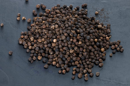 black pepper grain on wooden table in black