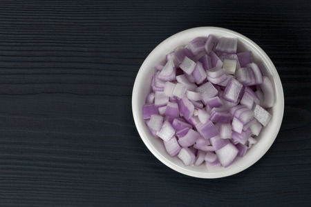 red onion slices in a bowl on a wooden backgroundの写真素材