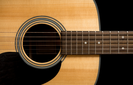 Yellow acoustic wooden guitar on a black backgroundの写真素材