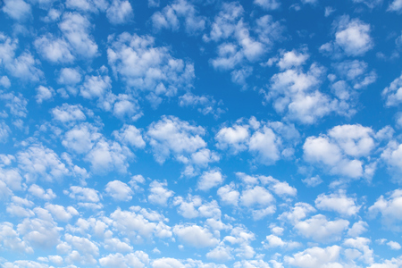 Nice small clouds. Cute fluffy cirrus clouds on a blue sky, background with a gradient effect.の写真素材